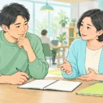 仕事の目的や進め方について、ノートを見ながら話し合う二人